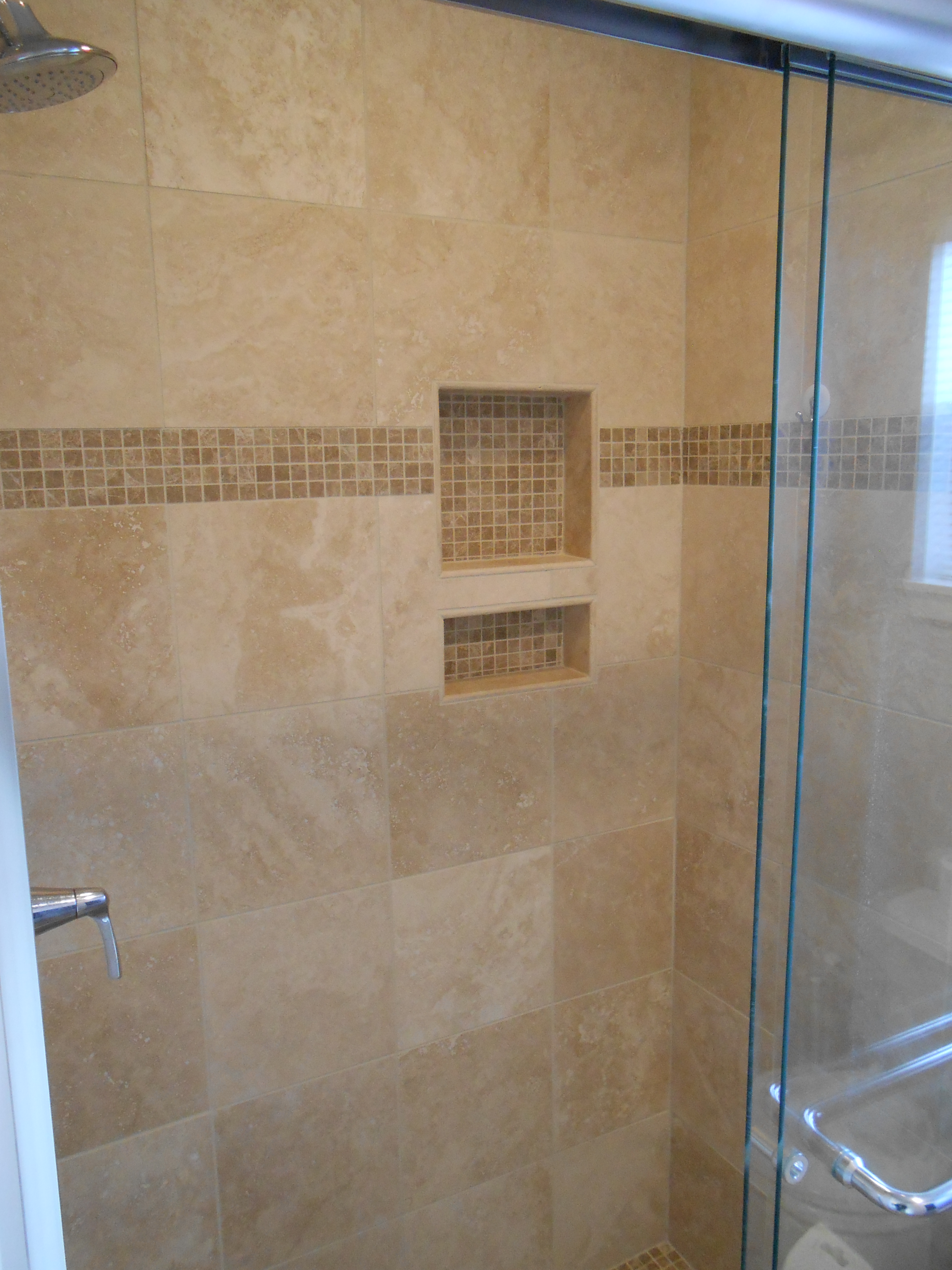 shower niche with travertine accent tiles